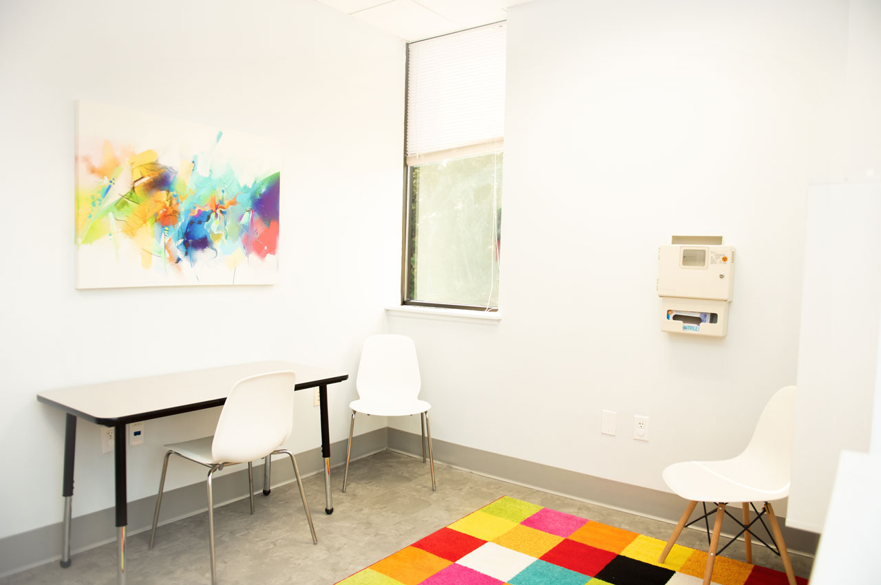 Carolina Therapeutics white office space with desk, chairs and bright colorful rug